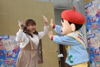 野原しんのすけ（右）とハイタッチをするりんごちゃん（左）。