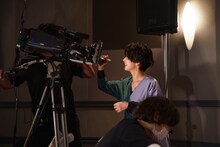 中継先の劇場にいるファンに向けて、サインをする石橋菜津美。