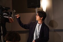 中継先の劇場にいるファンに向けて、サインをする中村倫也。