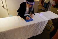 パンフレットにサインをする内藤瑛亮。