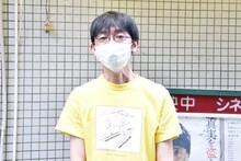 田中俊介がデザインしたシネマスコーレ応援Tシャツを着た坪井篤史。