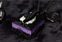 マレフィセント / エヴィルマジックプチケーキ ネックレス（税込1万1000円）、バッグチャーム（税込9900円）。