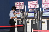 券売機を消毒する劇場スタッフ。