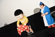 タイムふろしきをめくろうとするのび太(左)。