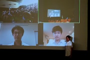「はりぼて」初日舞台挨拶の様子。スクリーン下段左から砂沢智史、五百旗頭幸男。舞台右手が本木克英。