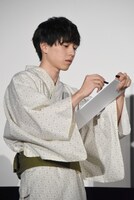 迷わずに川柳を短冊に書く坂東龍汰。