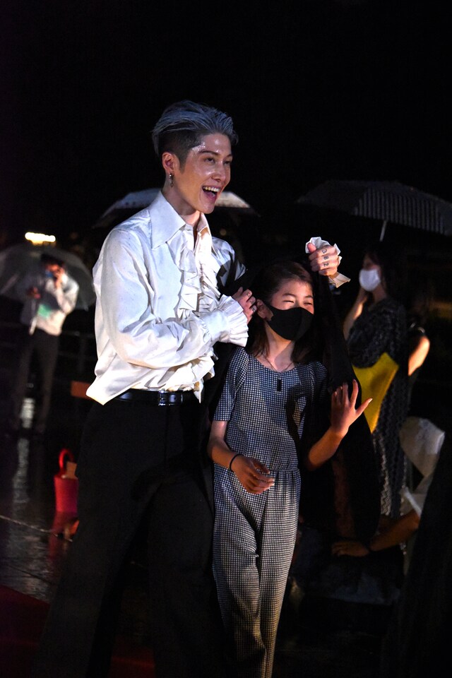 娘を雨から守るMIYAVI。