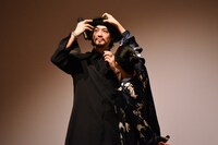 齊藤工（左）の顔が見えるよう、帽子のツバを上げる河瀬直美（右）。