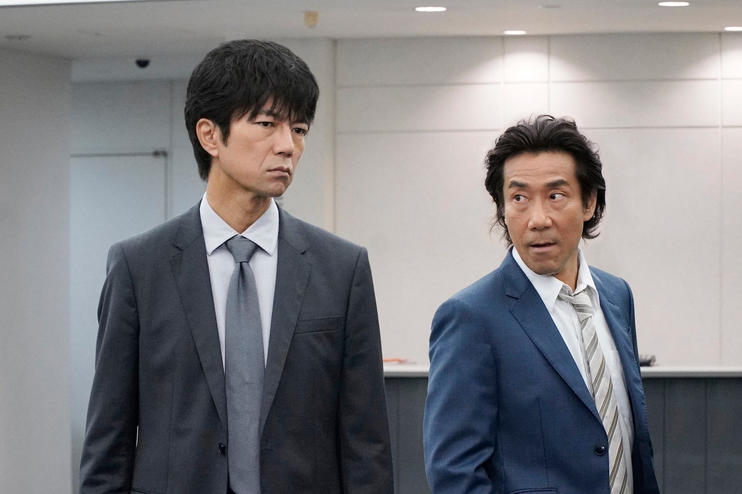 仲村トオル演じる朽木泰正（左）と、岸谷五朗演じる村瀬恭一（右）。