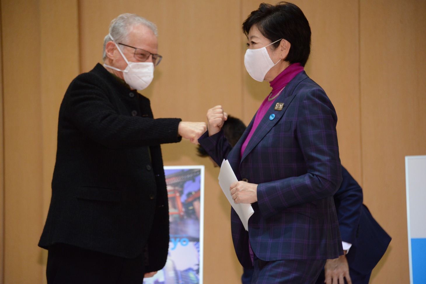 拳と拳を合わせ挨拶するマイケル・マン（左）と小池百合子（右）。