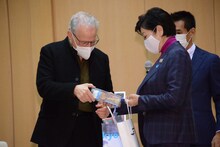 マイケル・マン（左）にけん玉をプレゼントする小池百合子（右）。