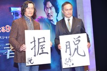 書を披露する豊川悦司（左）と渡辺謙（右）。