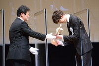 トロフィーを受け取る宮沢氷魚（右）。