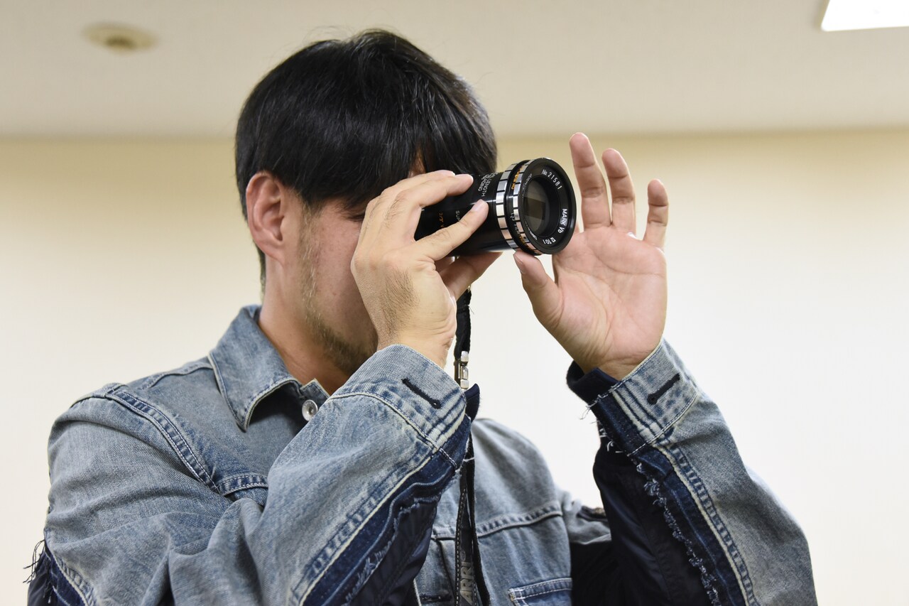 アングルファインダーを覗く山田康介。