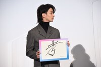 「考」と書かれたフリップを持つ横浜流星。