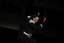 仮面ライダーファルシオンの変身シーンを再現する谷口賢志。