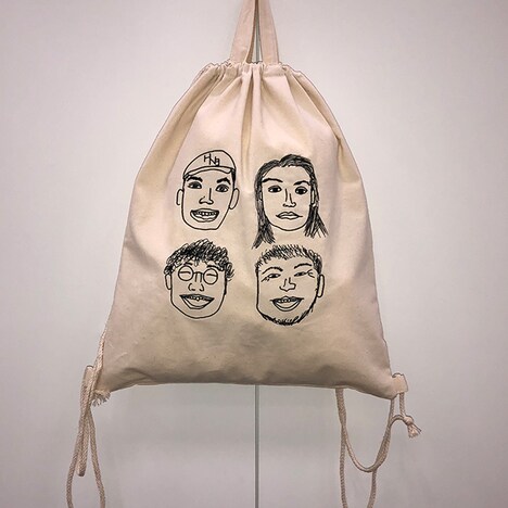 杉野遥亮によるイラストを使用した刺繍入りナップサック。