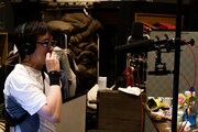 北田雅也がモニターの映像に合わせながら唐揚げを食べ、登場人物の咀嚼音を収録している様子。