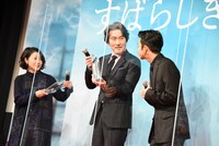 盾を受け取った西川美和（左）と、トロフィーを受け取った役所広司（中央）。