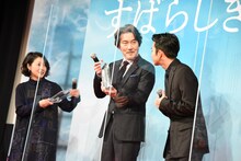 盾を受け取った西川美和（左）と、トロフィーを受け取った役所広司（中央）。