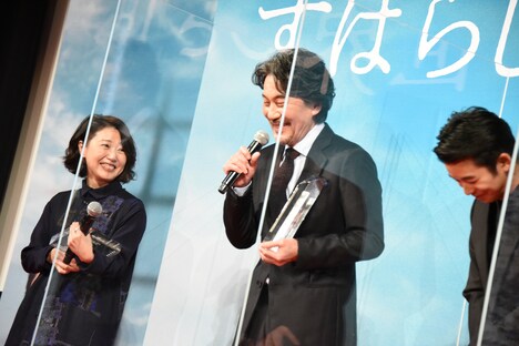 盾を受け取った西川美和（左）と、トロフィーを受け取った役所広司（中央）。