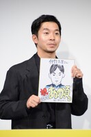 劔樹人が描いた自身の似顔絵を手にする仲野太賀。