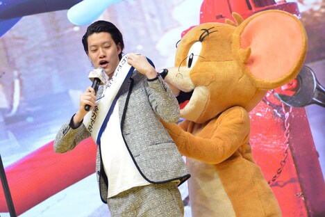 粗品（左）がたすきを掛けるのを手伝うジェリー（右）。