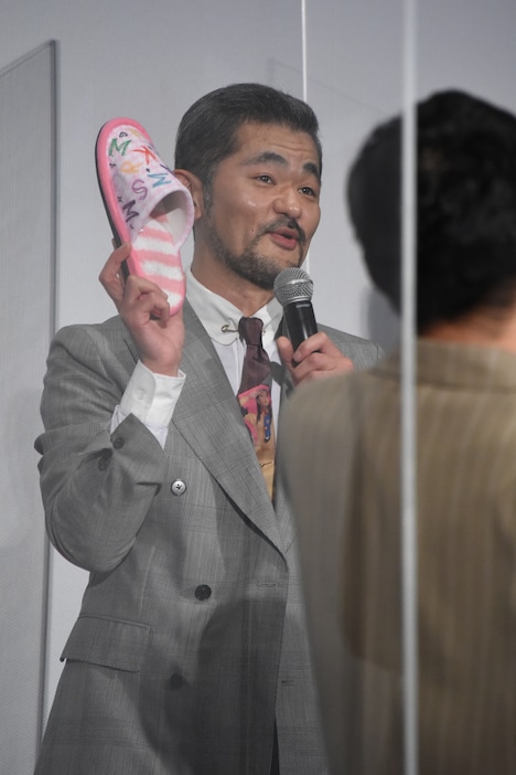 スリッパを見せる芹澤興人。