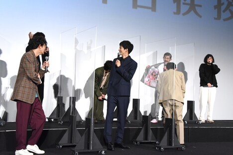 ジャケットの裏地を見せる芹澤興人(後列右から2人目)。