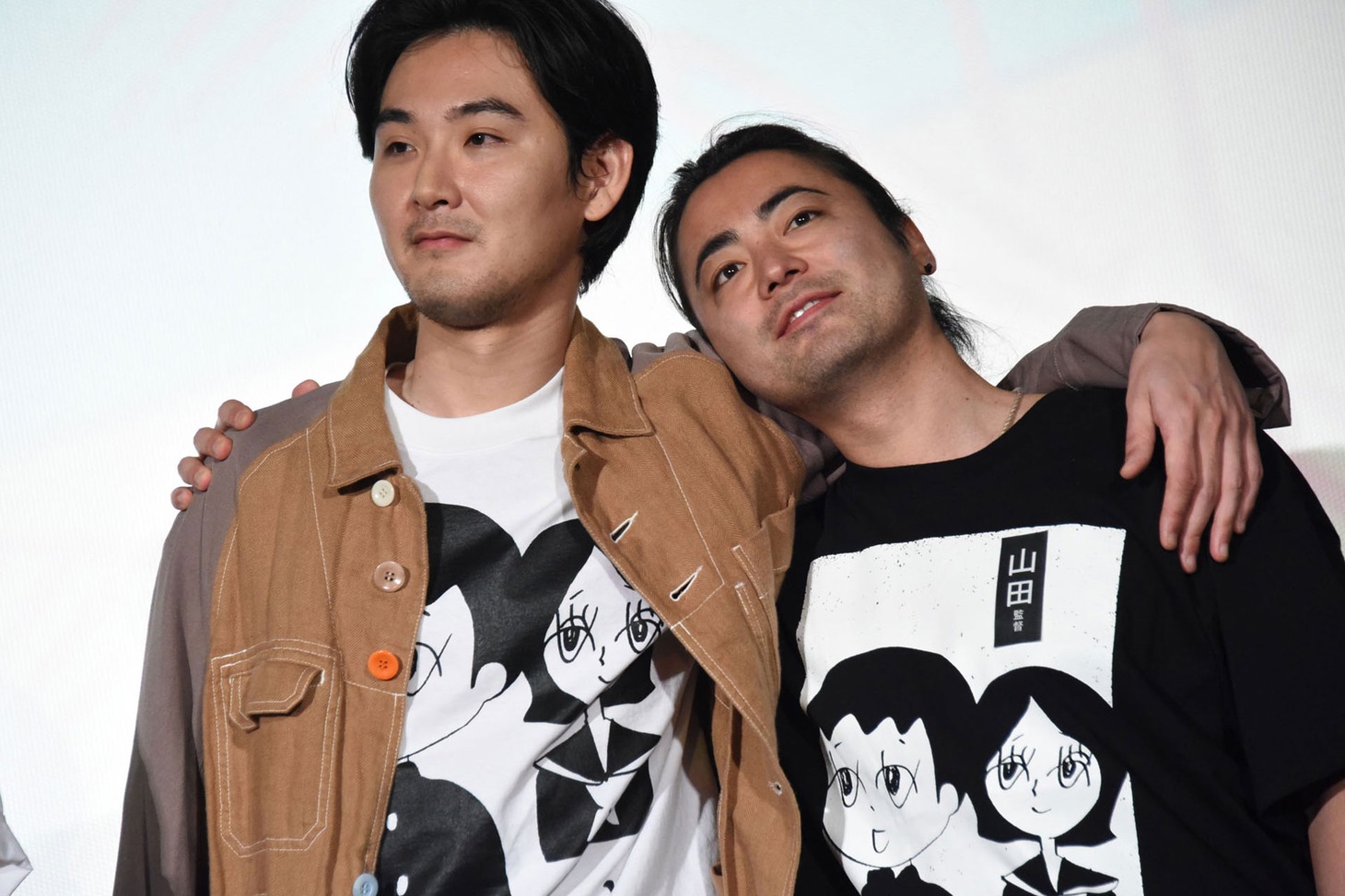 肩を組む松田龍平（左）と山田孝之（右）。
