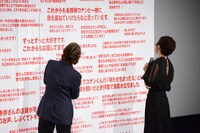 ボードに書かれたメッセージを読む高山みなみ（左）と山崎和佳奈（右）。