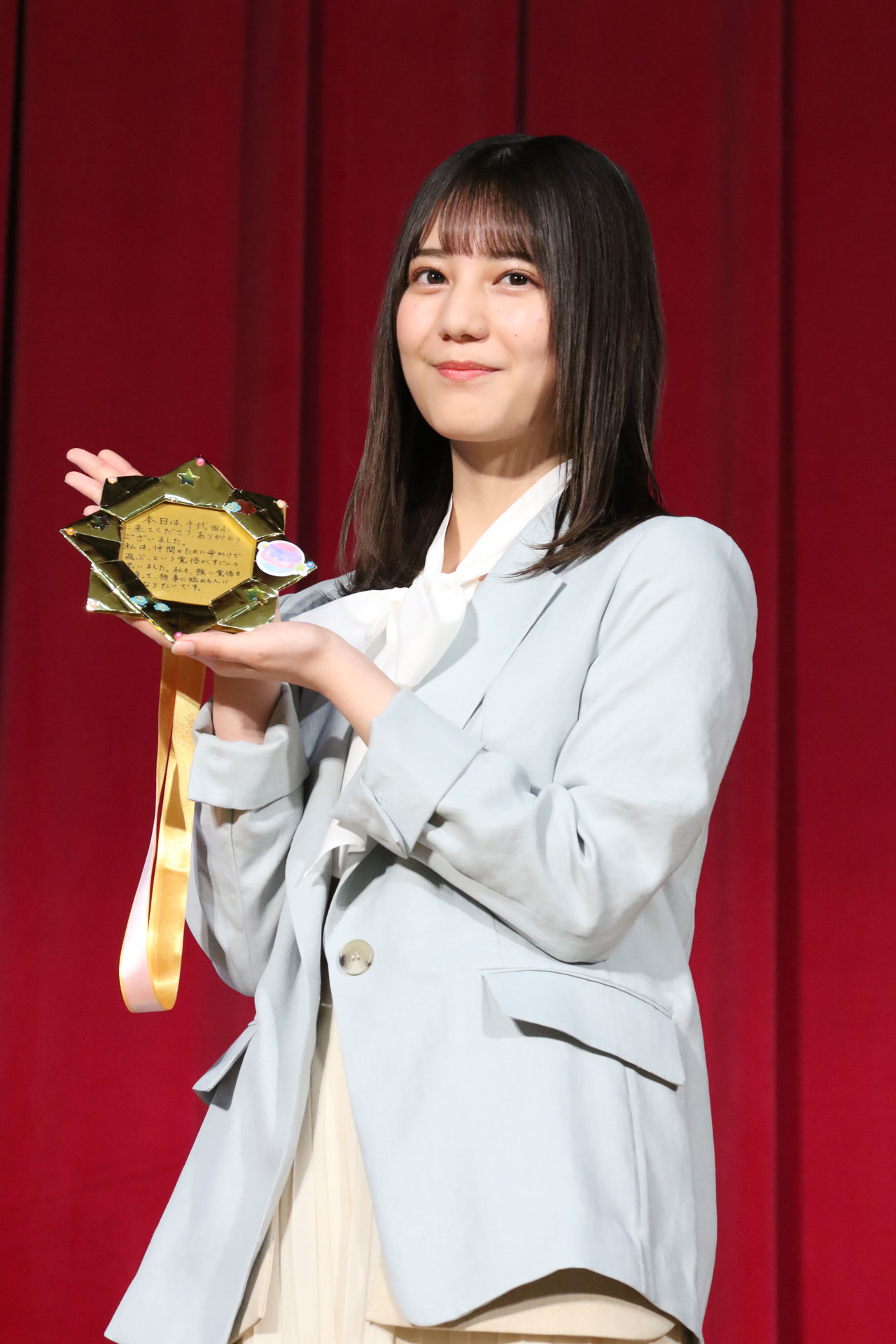 生徒たちから送られた“特製金メダル”を見せる小坂菜緒。