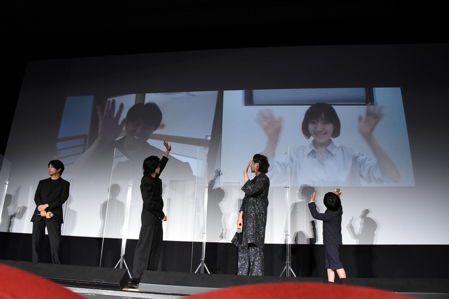 リモート参加の韓国人キャストに手を振る登壇者たち。