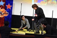 ボタン電池を拾うのを手伝う日野聡（右）と、「やめてください！ 僕炎上するんで！」と必死で止めようとするこがけん（左）。