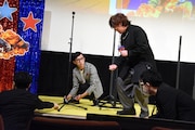 ボタン電池を拾うのを手伝う日野聡(右)。
