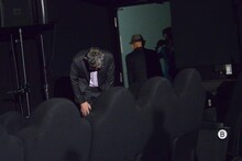 舞台袖から頭を下げる庵野秀明。