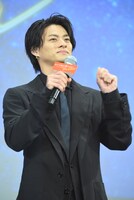 観客をまねて、スティックバルーンをたたくふりをする平野紫耀。