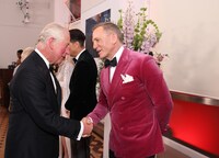 チャールズ皇太子（左）と握手を交わすダニエル・クレイグ（右）。
