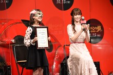 記念日の証明書を見せる小畑乃々（左）と、喜ぶ深田恭子（右）。