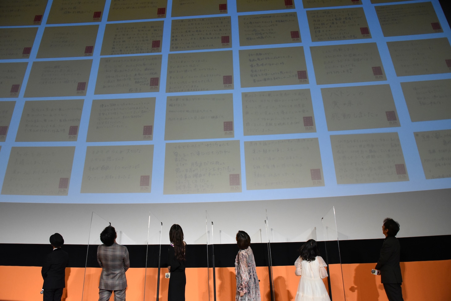 映画を鑑賞した人からのメッセージを読む登壇者たち。