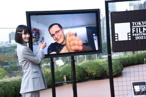 画面越しに握手を交わす橋本愛(左)とバフマン・ゴバディ(右)。