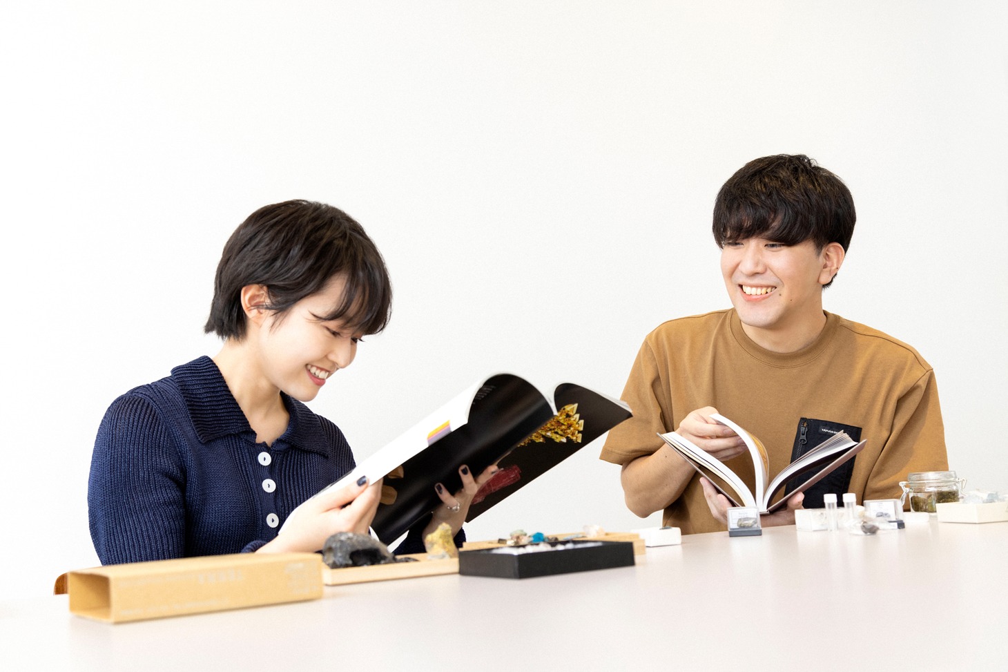 互いに持ち寄った写真集を交換して読む伊藤万理華（左）と大童澄瞳（右）。