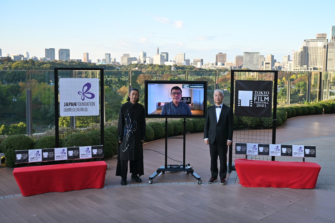 「アジア交流ラウンジ」の様子。左から永瀬正敏、リモートで参加したブリランテ・メンドーサ、モデレーターを務めた石坂健治。