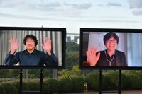 笑顔で手を振るポン・ジュノ（左）と細田守（右）。