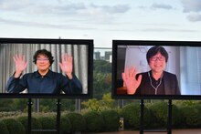 笑顔で手を振るポン・ジュノ（左）と細田守（右）。