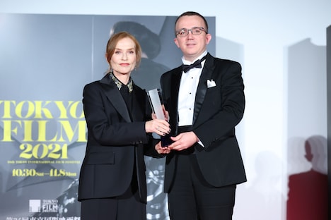 左からイザベル・ユペール、「ヴェラは海の夢を見る」監督に代わって登壇した、駐日コソボ共和国大使館の臨時代理大使アルバ・メフメティ。