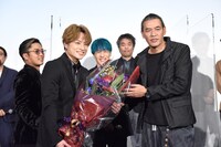花束贈呈後に記念撮影をする白濱亜嵐（前列左）とSABU（前列右）。意図せずセンターに入ってしまいはにかむ中務裕太（後列中央）と、「写りたいな」と寄ってきた数原龍友（後列左）。