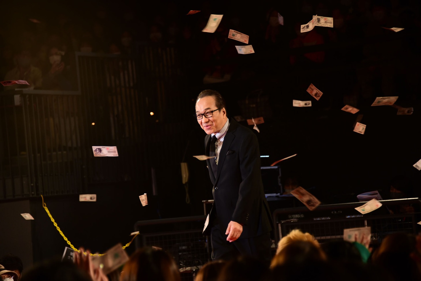 “壱億円札”が舞う中、登壇した小日向文世。