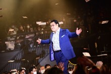 “壱億円札”が舞う中、登壇した小手伸也。