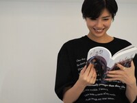 「君は永遠にそいつらより若い」主演の佐久間由衣がパンフレットを読む様子。